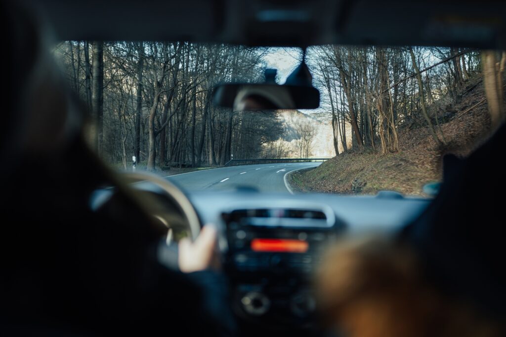 Experience the tranquility of driving through a peaceful forest road during the day.